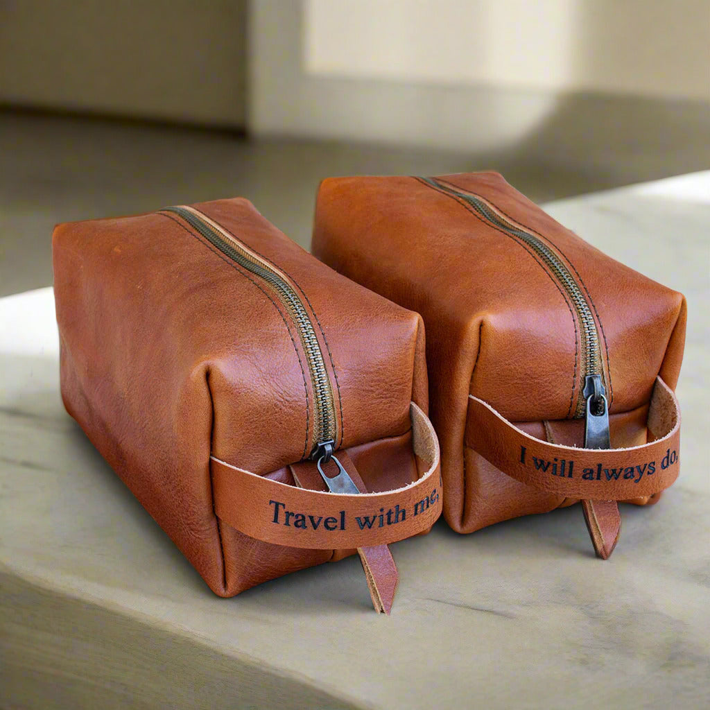 Handmade Dopp kit in premium tan Italian leather, shown in medium size. Personalized with an engraved text.