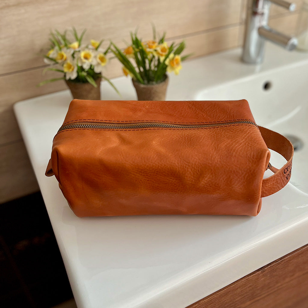 Handmade Dopp kit in premium tan Italian leather, shown in large size. Customizable with an engraved name and incription.