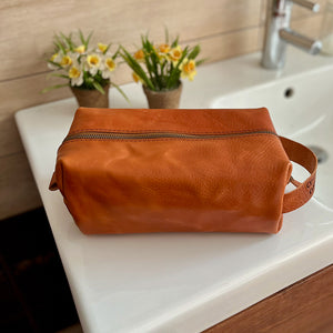 Handmade Dopp kit in premium tan Italian leather, shown in large size. Customizable with an engraved name and incription.