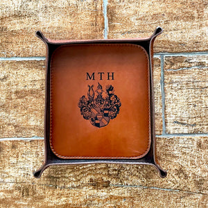 Brown leather tray with monogram on a brick wall background
