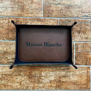 Brown leather tray featuring a brand's name on an additional stitched, reinforced base.