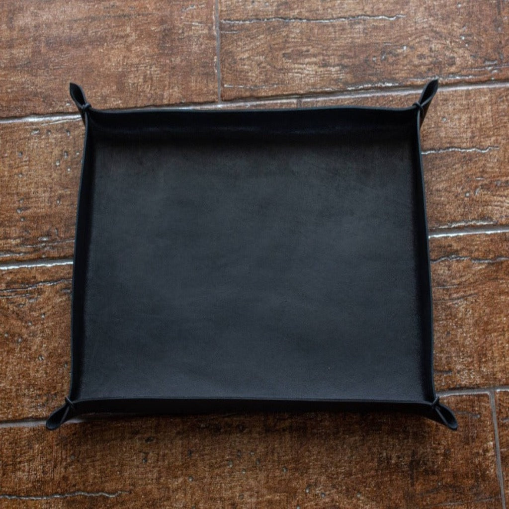 A black-colored, medium size Italian leather tray with leather cords at each corner, non-engraved