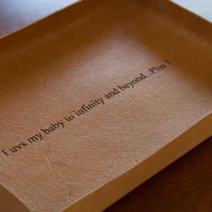 A rectangular natural-colored tray made from Italian full-grain leather, engraved with an inscription.