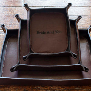 Set of three, small, medium, and large, engraved Italian leather valet trays in brown color.