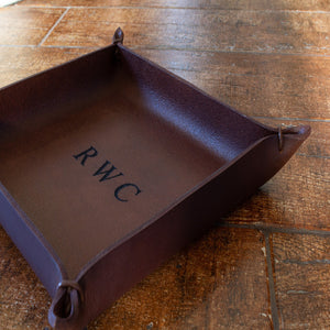 A medium-sized tray in brown Italian full-grain leather that has been customised with engraved initials.