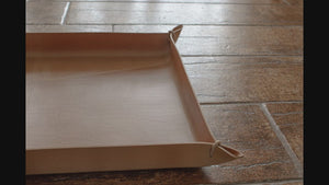 A video presentation of Italian leather valet trays in various sizes and colors, held in the corners with leather cord.