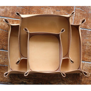 Set of three small, medium, and large non-engraved Italian leather valet trays in natural color.