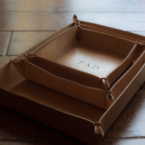 Set of three sizes of trays in natural Italian full-grain leather, customised with engraved initials.