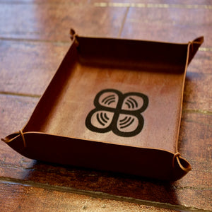 A small tray made of Italian full-grain leather in the color brown whiskey, customised with an engraved logo.